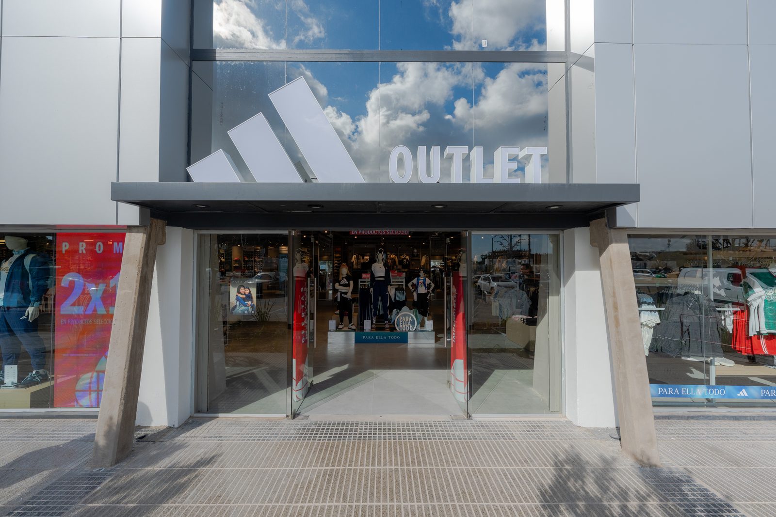 Frente del local adidas Outlet en XTiro, con vidrieras y el logo sobre la entrada.